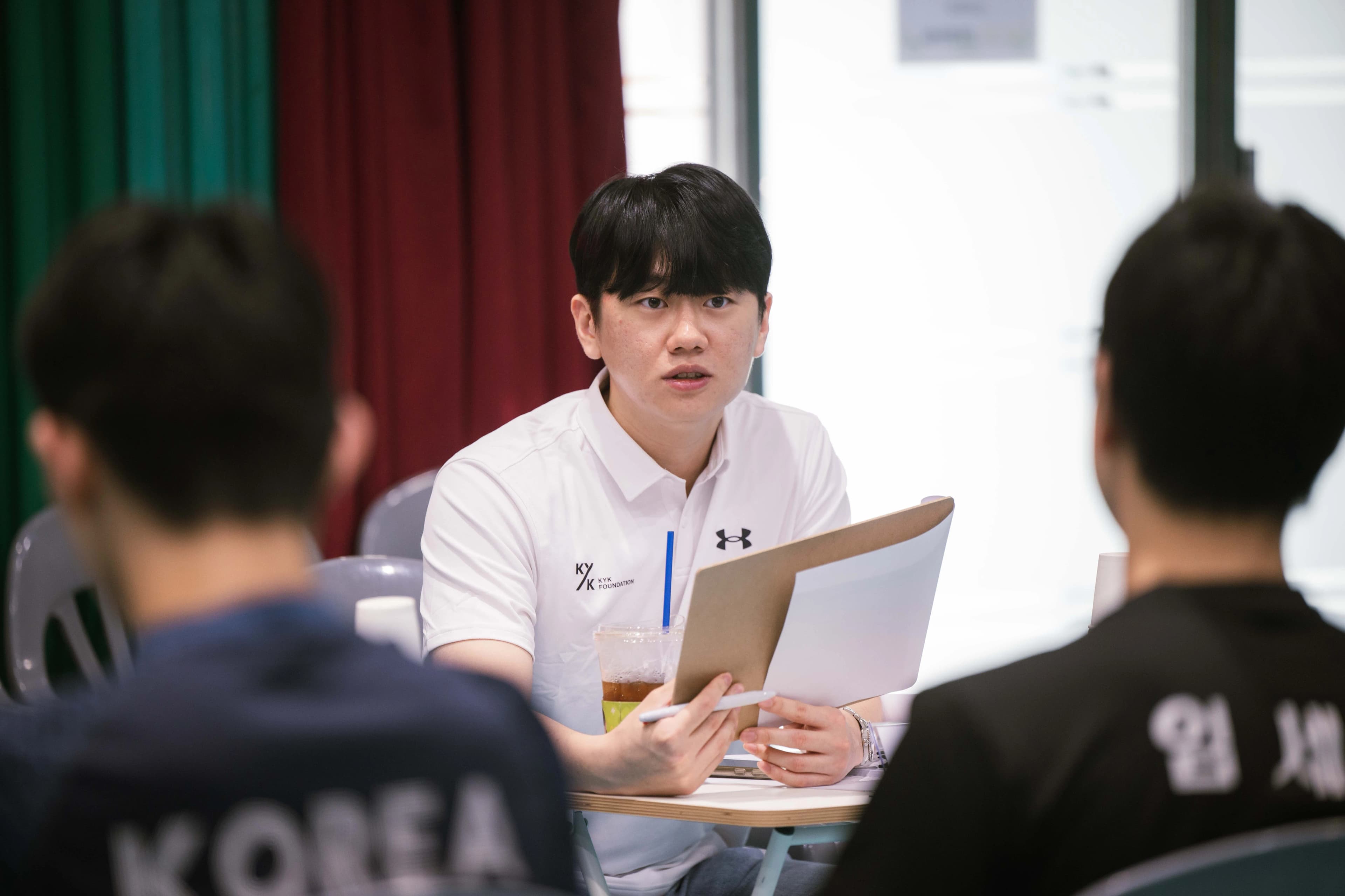 A judge holding documents and talking with participants