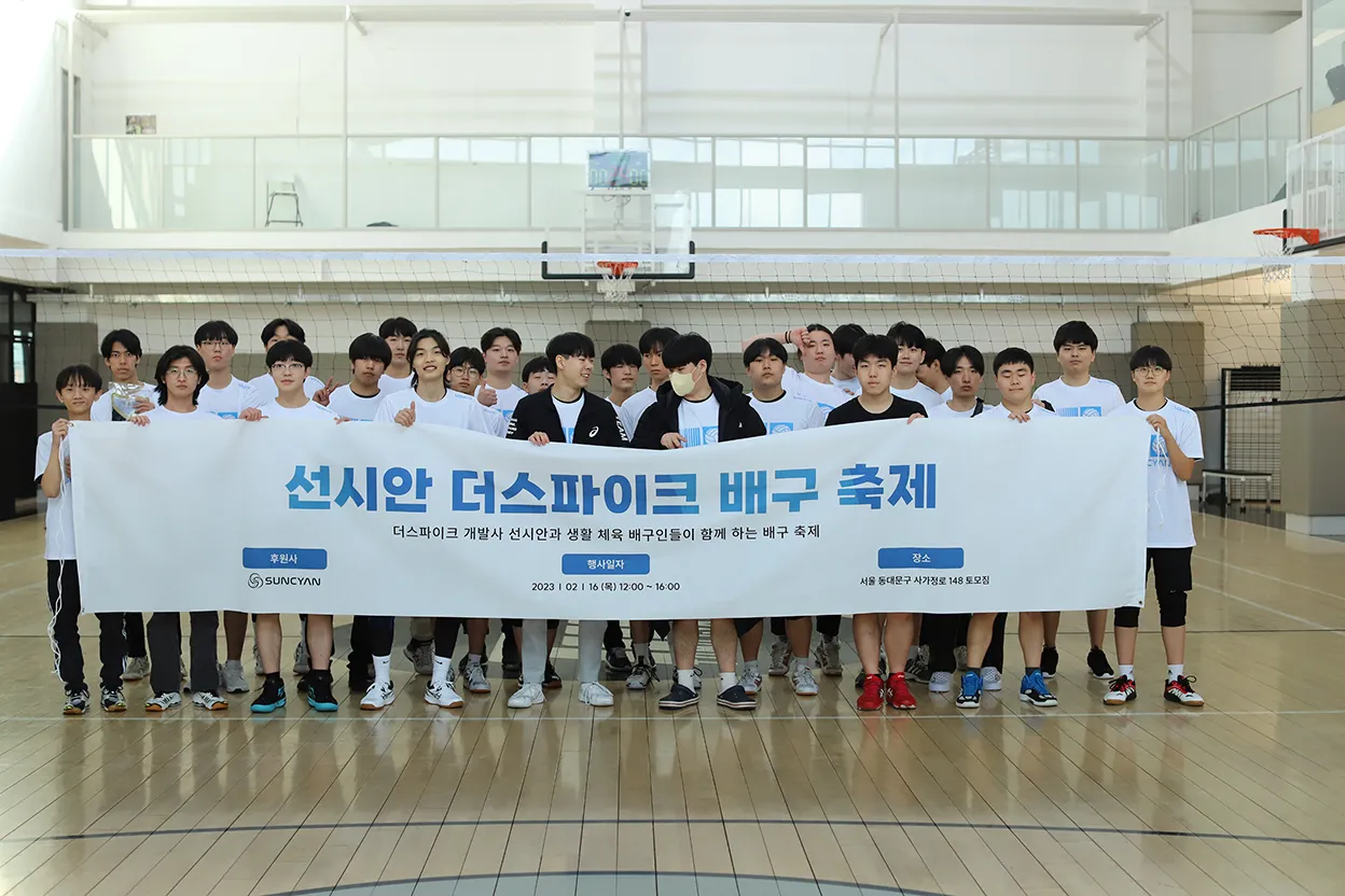 Participants posing together with a SUNCYAN The Spike Volleyball Festival banner