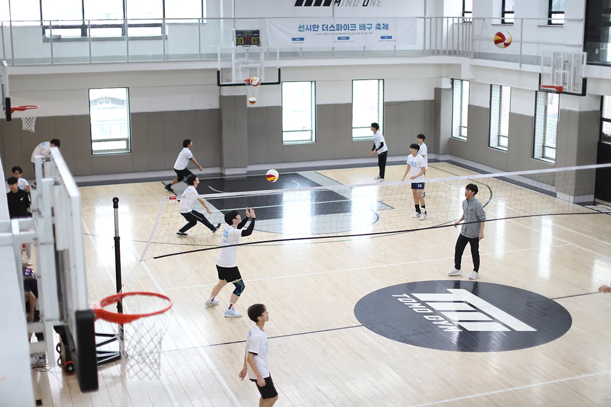 Participants practicing volleyball in a gym at the SUNCYAN The Spike Volleyball Festival